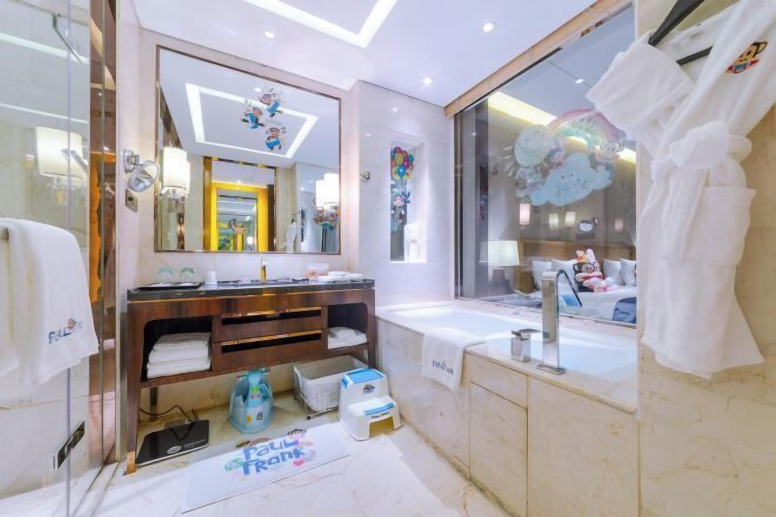 Ein modernes Badezimmer mit großem Spiegel, einer Badewanne und einem Waschtisch.
