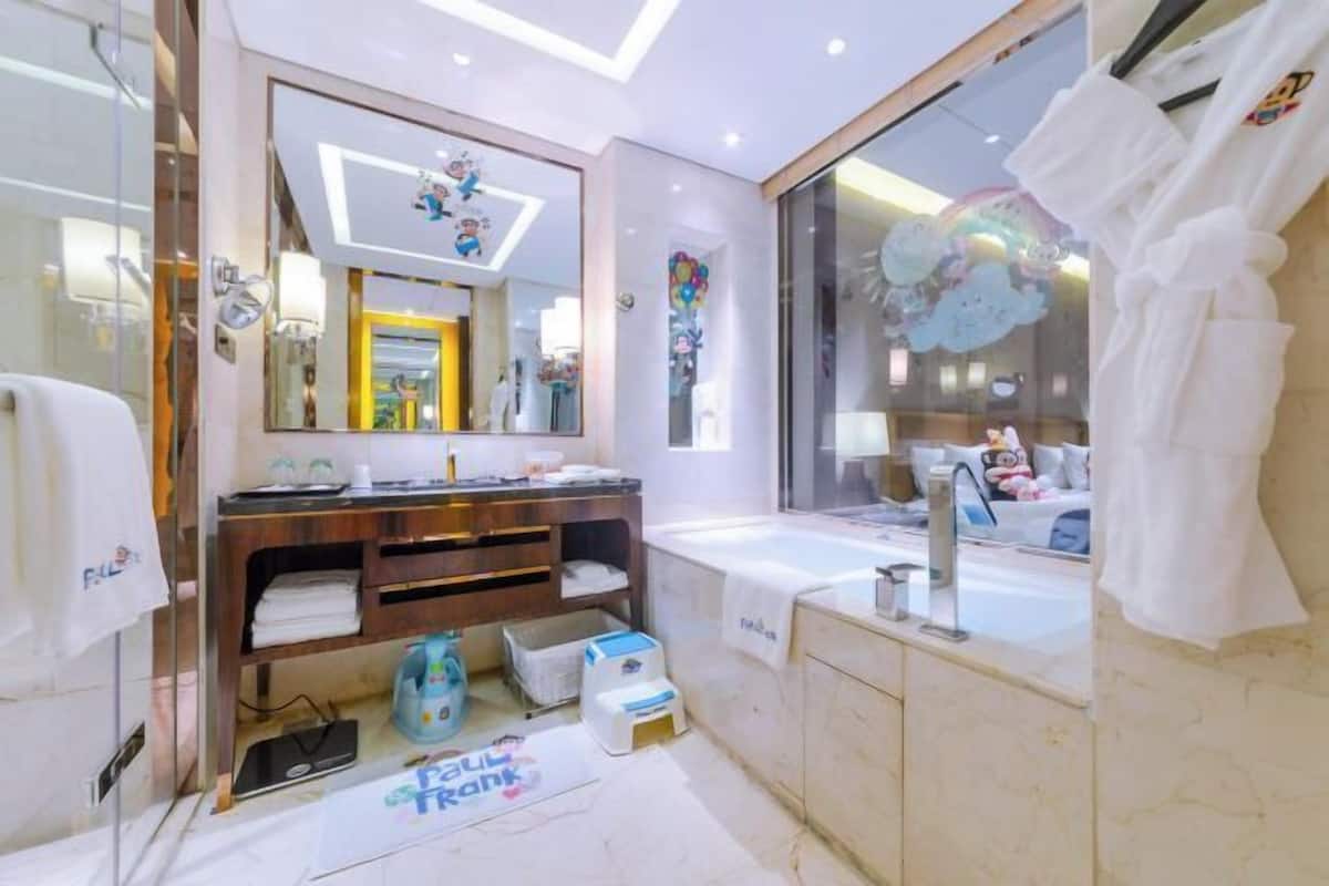 Ein modernes Badezimmer mit großem Spiegel, einer Badewanne und einem Waschtisch.