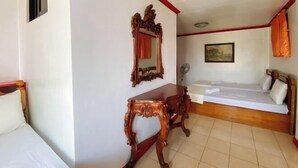 A room with a bed, a wooden table, a mirror, and a painting on the wall. - RedDoorz Hostel @ Tita Aidz Inn Baguio (Baguio)