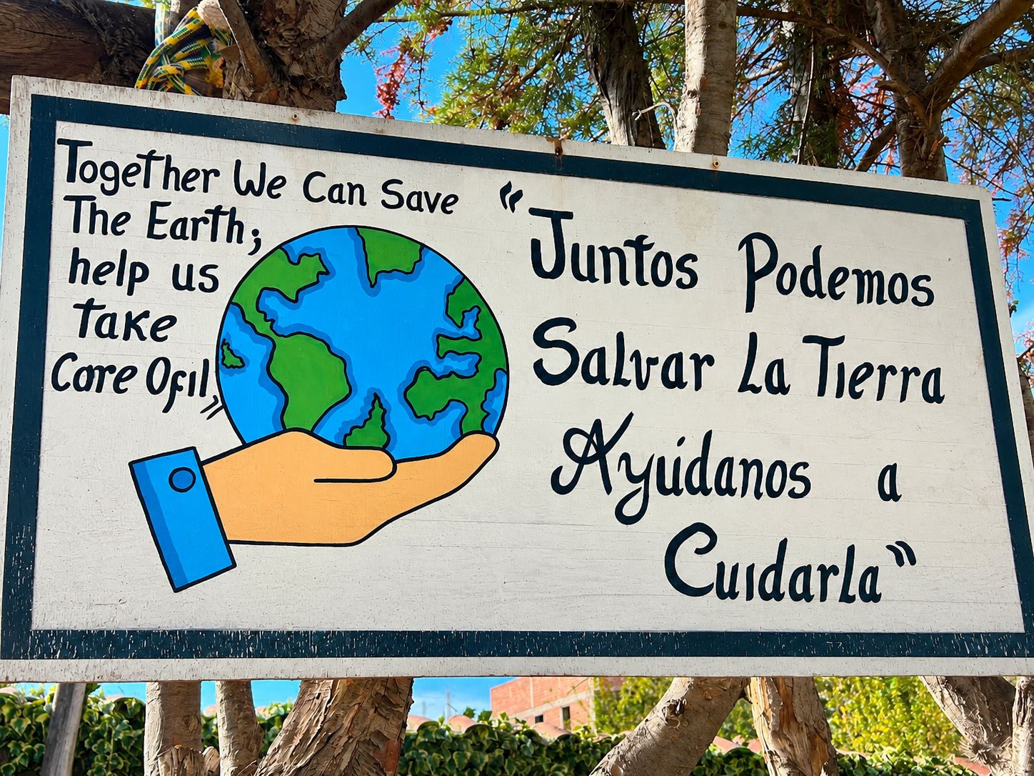 A sign with a hand holding a globe, promoting environmental conservation.