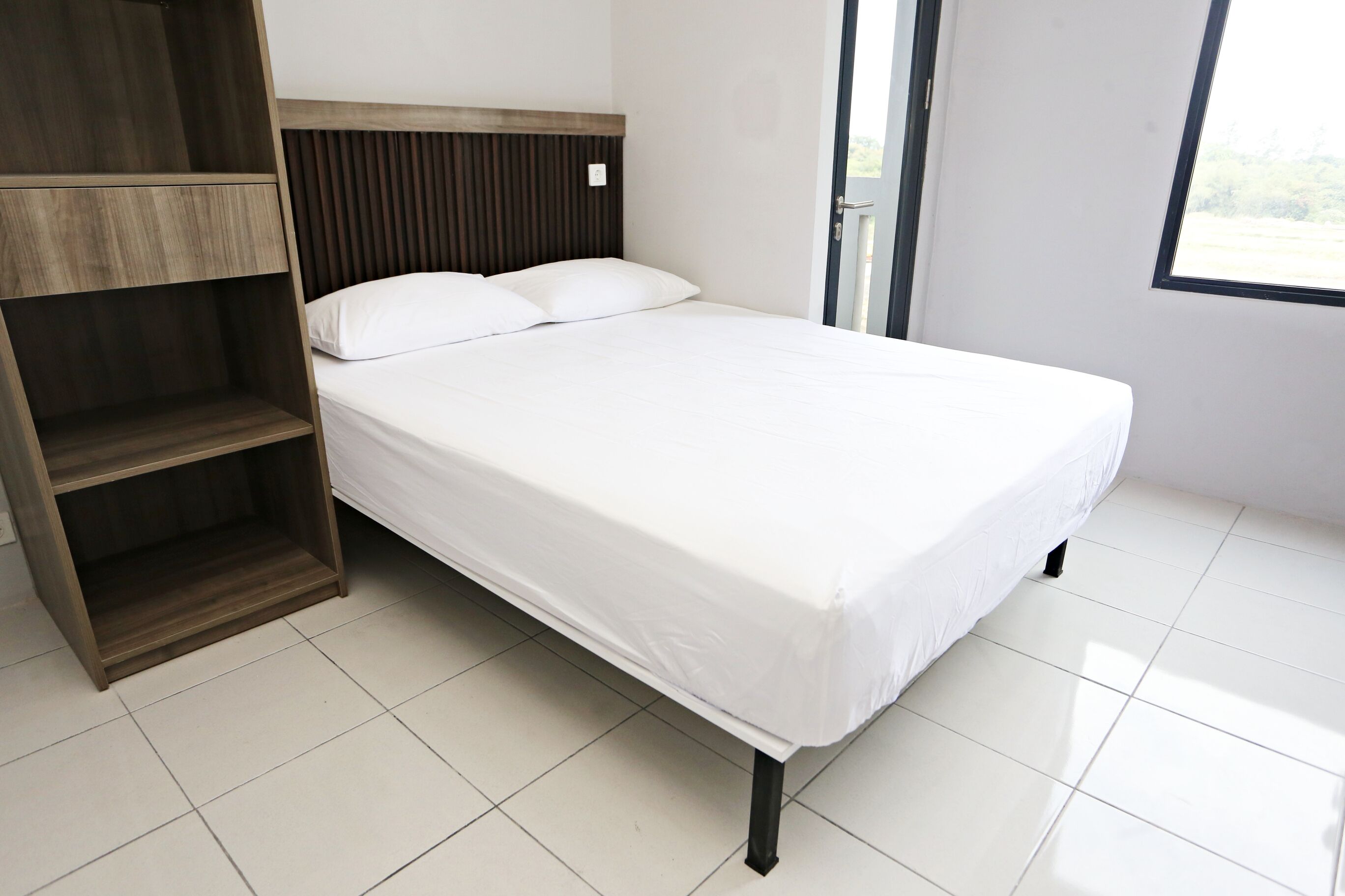 Una camera da letto con un letto, un armadio in legno e una finestra.