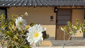 A traditional building with a tiled roof, a wooden door, and a small window. - Cocon Setouchi (Suooshima)