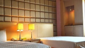 A hotel room with two beds, a padded headboard, bedside lamps, a telephone, and a cabinet. - Rainbwlake motel (Yunlin)