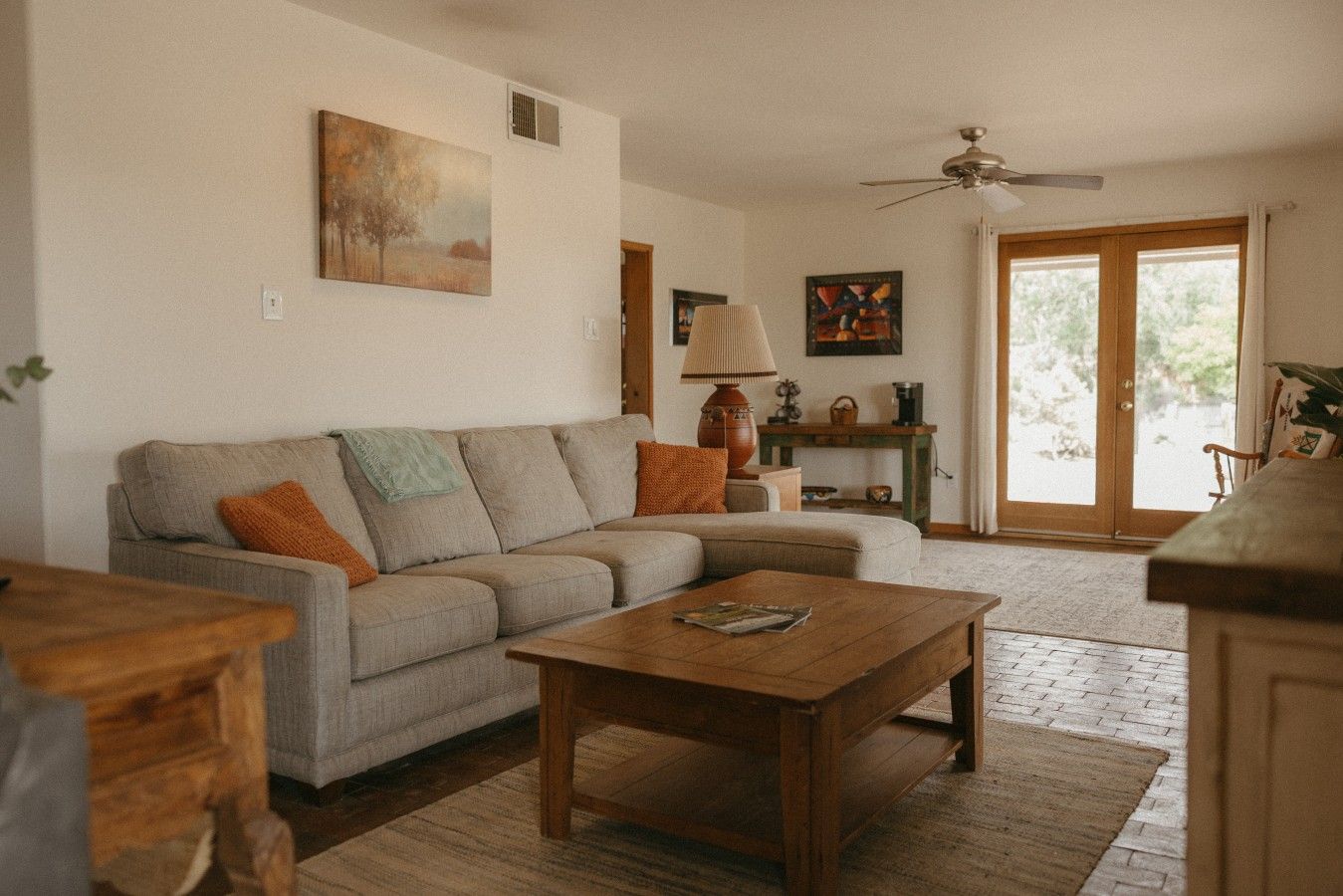 A living room with a sofa, coffee table, and a ceiling fan.