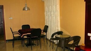 Una habitación de hotel con una mesa de comedor, cuatro sillas, una mesita redonda y una cama.