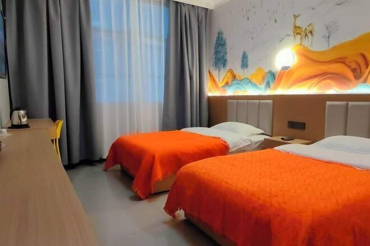 Une chambre d’hôtel avec deux lits, un bureau et une grande fresque murale.