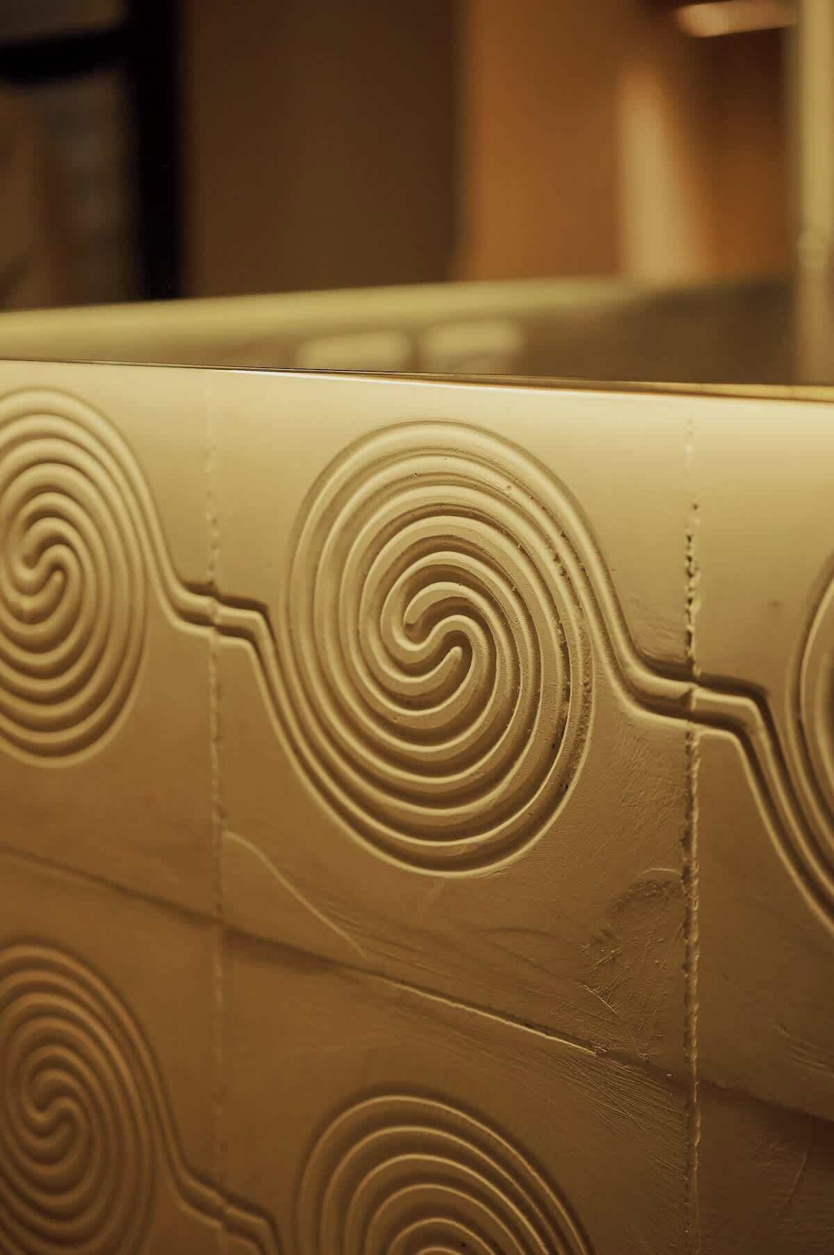 A close-up of a textured wall with a spiral pattern.
