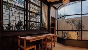 A corner room with a large window, wooden table, and chairs.