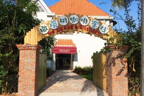 A traditional Chinese gate with a red awning and a sign above it. - Olive Tree Coffee Inn (Haikou)