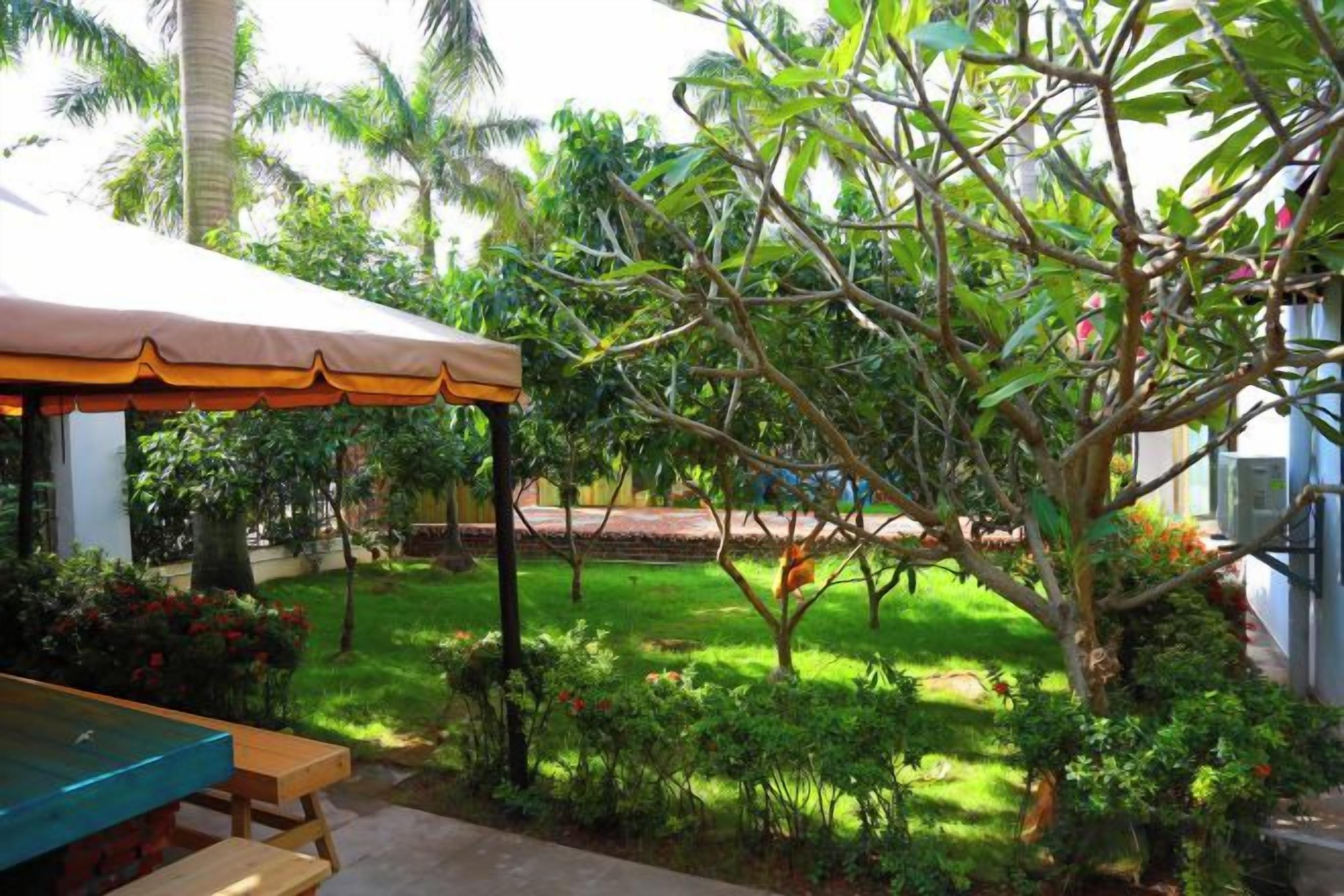A covered outdoor seating area with a table and benches.