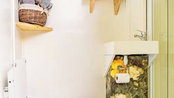 Een kleine badkamer met toilet, wastafel en douche.