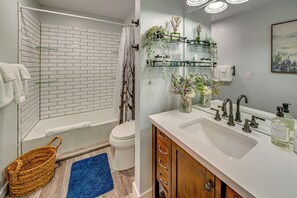Ein Badezimmer mit Waschbecken, Spiegel und Duschkabine mit weißen Fliesen.