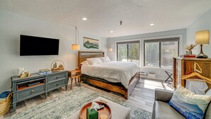 A bedroom with a bed, bedside tables, a dresser, a TV, a window, and a view of the outdoors. - Ski Retreat w/ Hot Tub Access in Winter Park! (Winter Park)