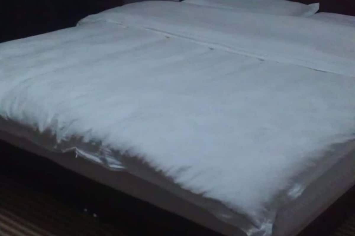 Una cama con ropa blanca y cabecera de madera.