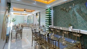 A spacious dining area with a long table, chairs, and a ceiling fan.