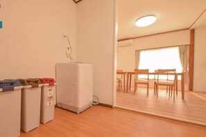 Une chambre dotée d’une kitchenette, d’une grande fenêtre et d’un coin repas avec des meubles en bois.