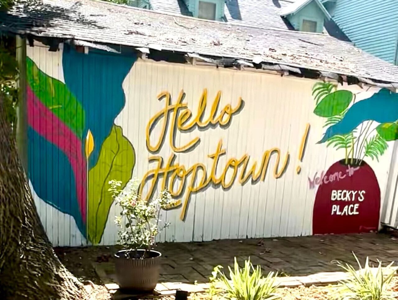 En färgstark väggmålning med texten ”Hej Hopetown!” och en skylt som lyder: ”Välkommen till BECKY’S PLACE”.