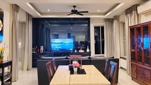 A modern living room with a dining area, a television, and a cabinet. - Wan D Villa Pattaya (Pattaya)