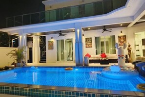 Una casa moderna con piscina, balcón y escalera que sube al piso superior.