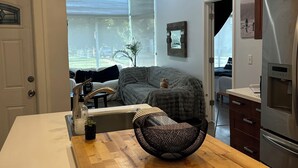 A modern kitchen with a wooden island, stainless steel appliances, and a large window providing natural light. - Historic Vintage House Downtown Grand Rapids  (Grand Rapids)