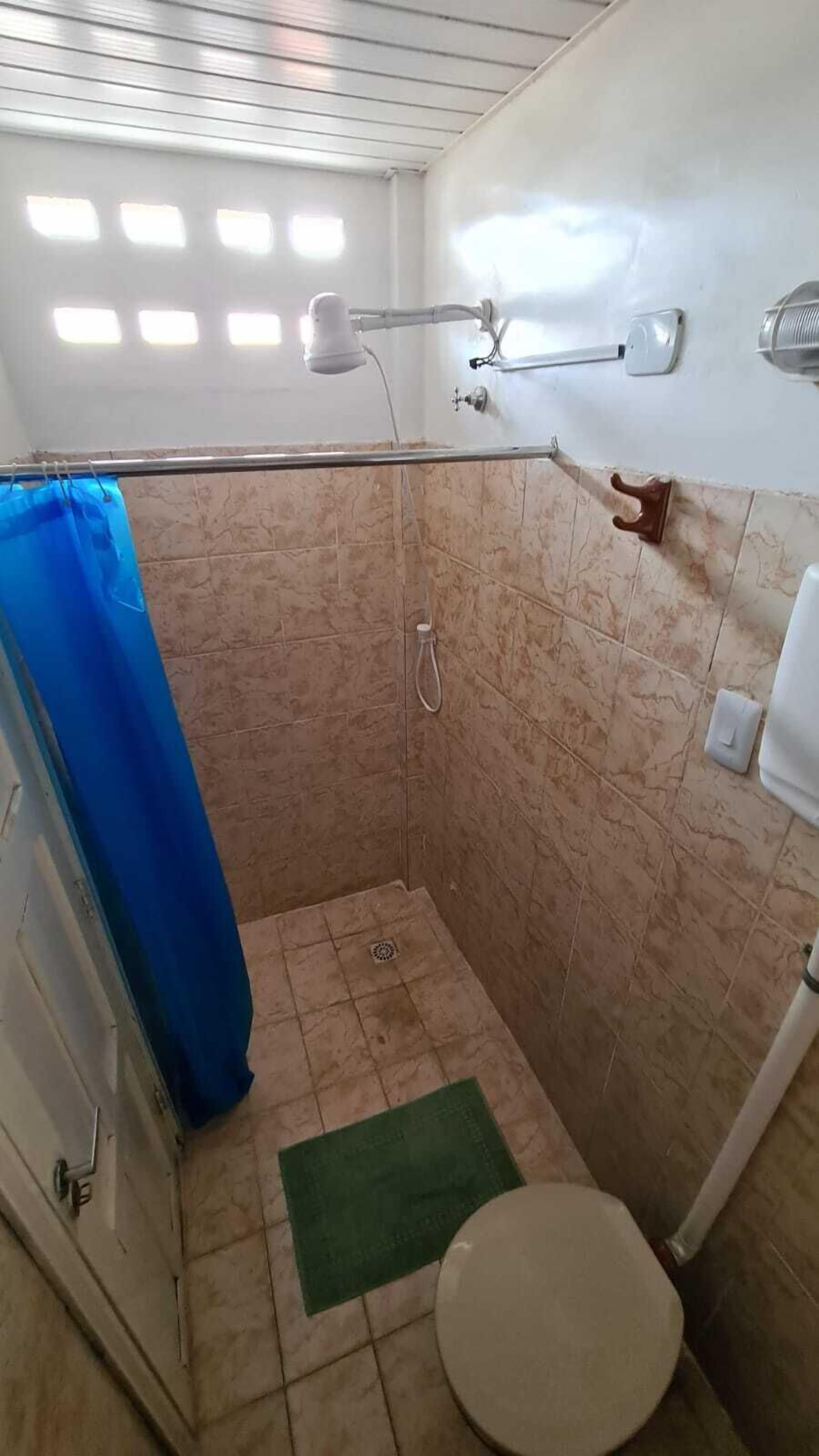 Eenvoudige tweepersoonskamer | Badkamer | Een douche, handdoeken, zeep, toiletpapier