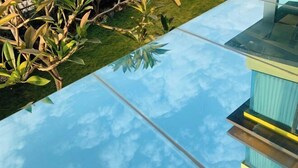 Un edificio moderno con facciata in vetro che riflette il cielo.