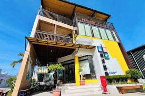 A multi-story building with a balcony, a sign with a star symbol, and a red mailbox. - Lohas Island B&B (Pingtung)