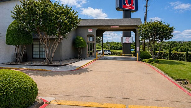 A motel with a clear entrance, a sign indicating 6 suites, and a welcome sign.