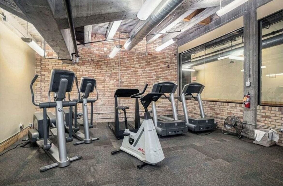 A gym with four treadmills, two elliptical machines, and a stationary bike.