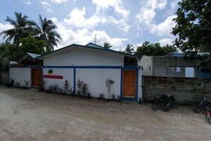 A single-story building with a flat roof, a front door, and a small porch area. - Origami Inn Himandhoo (Himandhoo)