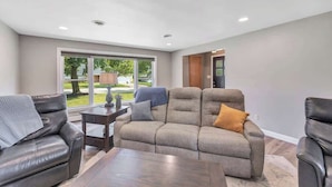 A modern living room with a sectional sofa, a coffee table, and a fireplace. - Charming 4-Bedroom Home, Short Walk to Lambeau (Green Bay)