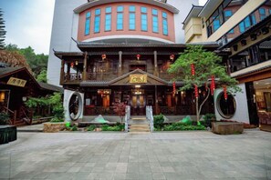 Un edificio tradicional con fachada curva, una entrada central con escalones y un letrero sobre la puerta.