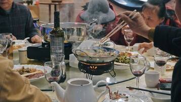 A dining table with various dishes, a teapot, and a bottle of wine.