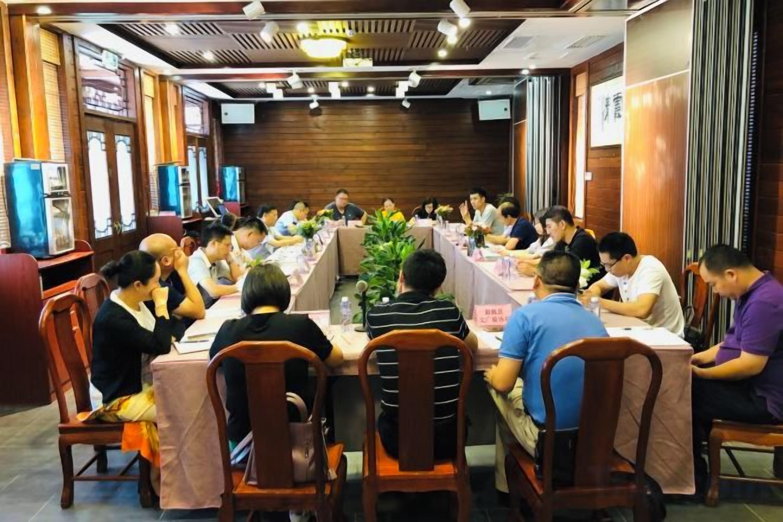 A conference room with round tables, chairs, and a central plant.