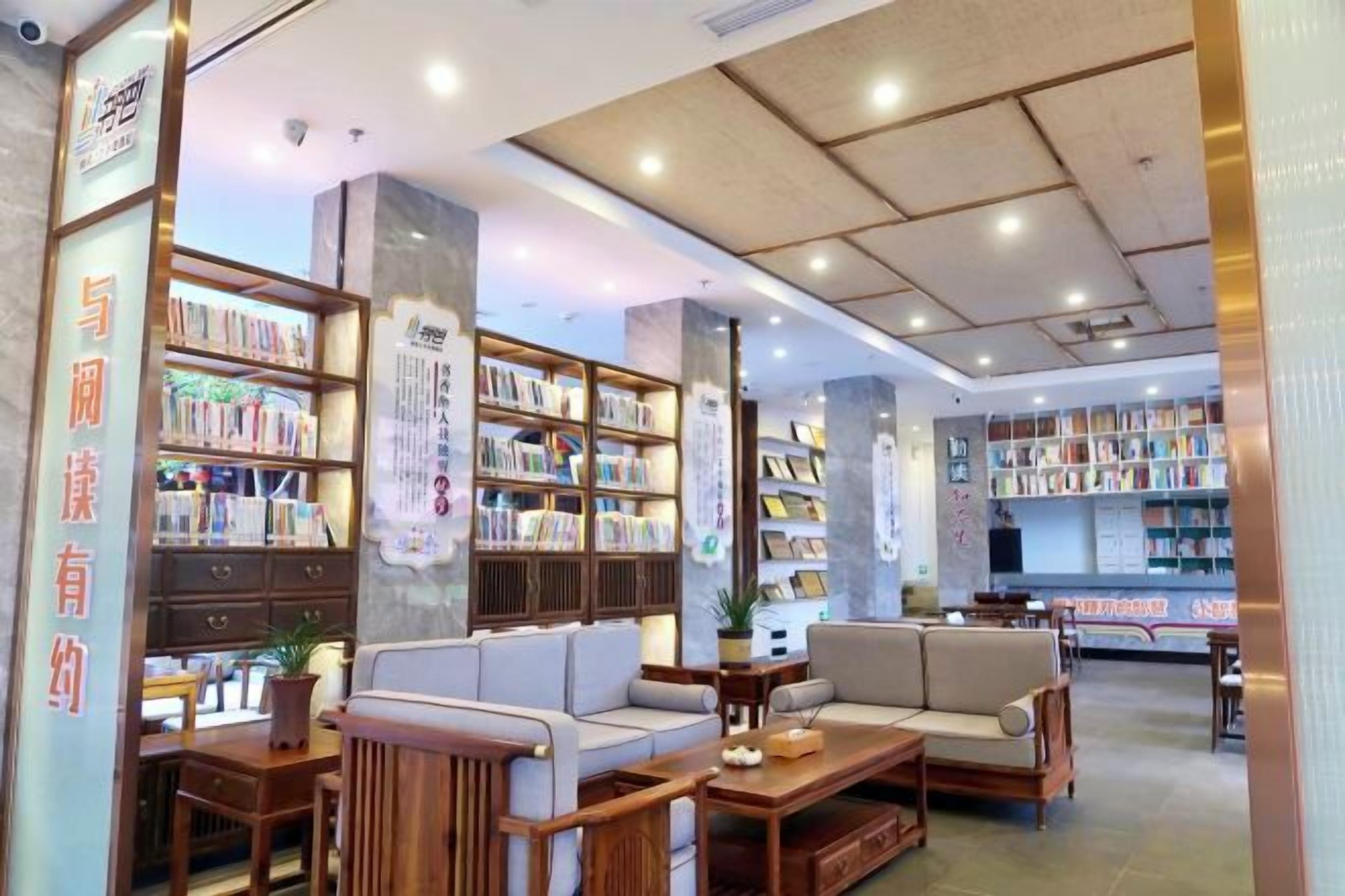 Eine Bibliothek mit Bücherregalen, Sitzbereichen und einem Empfangstresen.