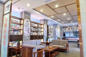 A library with bookshelves, seating areas, and a reception desk. - Renhua Shaozhou Impression Boutique Cultural Hotel (Renhua)