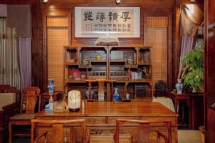 Una habitación tradicional japonesa con una mesa de madera para comer, sillas y una estantería.