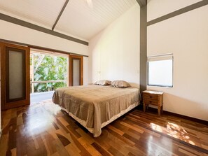 A bedroom with a large bed, a small bedside table, and a window. - Casa térrea com piscina e cozinha de cinema | Granja Viana (Jandira)