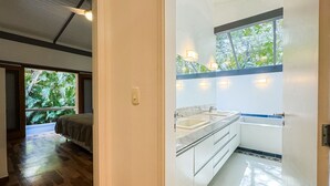 A modern bathroom with a large window, a double sink, and a wooden floor. - Casa térrea com piscina e cozinha de cinema | Granja Viana (Jandira)