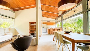 A modern interior with a dining area, kitchen, and living space. - Casa térrea com piscina e cozinha de cinema | Granja Viana (Jandira)