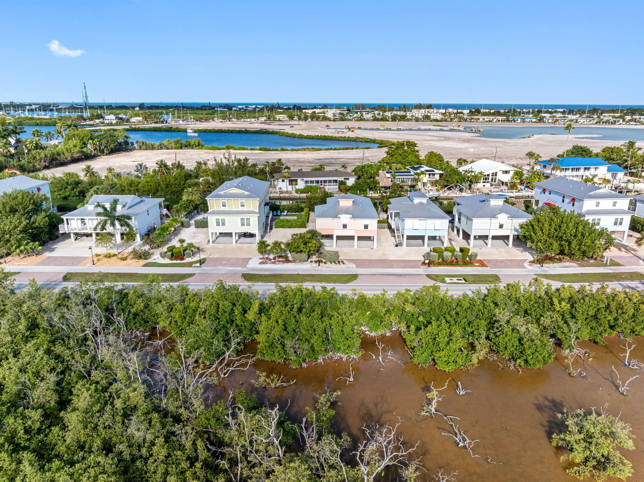 A coastal residential area with houses, a marina, and a beach.