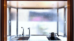 A kitchen with a sink, faucet, and stove. - Ronchamp Villa (Tainan)