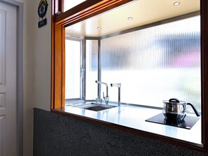 Een mini-koelkast, een magnetron, kookgerei, borden en bestek