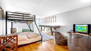 A compact room with a bunk bed, a television, and a gaming console. - Walk to beach, shuffleboard, and bunk room (Old Orchard Beach)