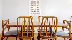 A dining area with a wooden table and chairs, a poster on the wall, and a white ceiling light. - Walk to beach, shuffleboard, and bunk room (Old Orchard Beach)