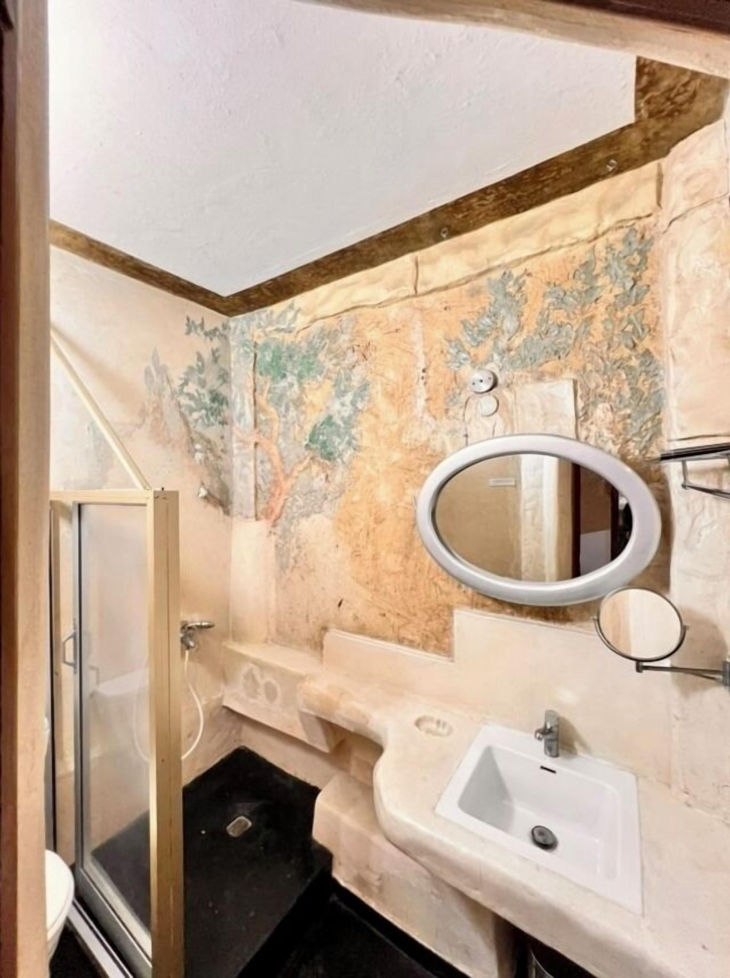 Ein Badezimmer mit Dusche, Waschbecken und Spiegel.