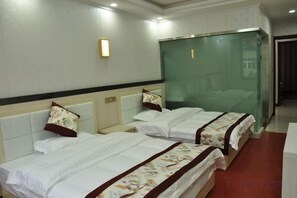 A hotel room with two beds, a glass partition, and a nightstand.