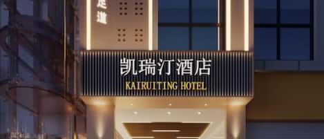 The exterior of Kairutting Hotel with illuminated signage and a modern architectural design.