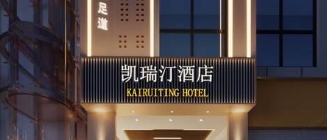 The exterior of Kairutting Hotel with illuminated signage and a modern architectural design.