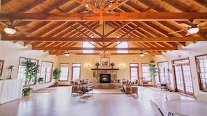Una habitación amplia con techo de madera alto, chimenea y varias zonas de estar.